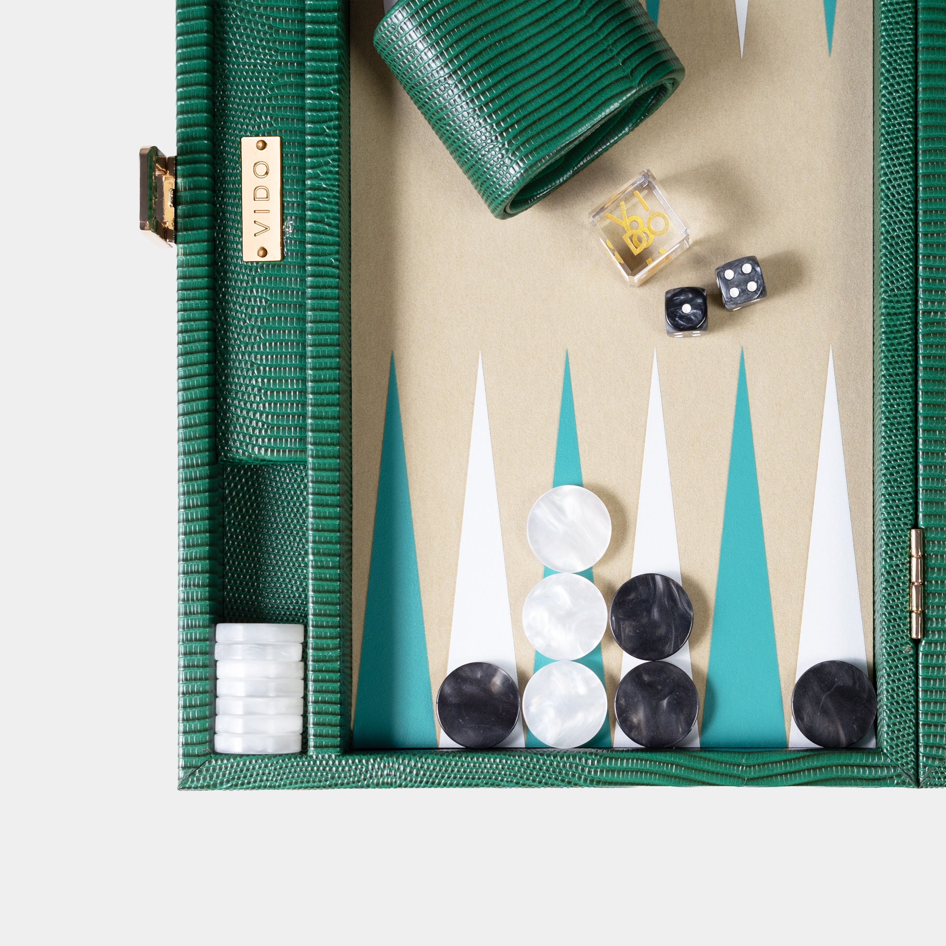 Backgammon set with pieces and dice on a beige board, green case, and VIDO branding.