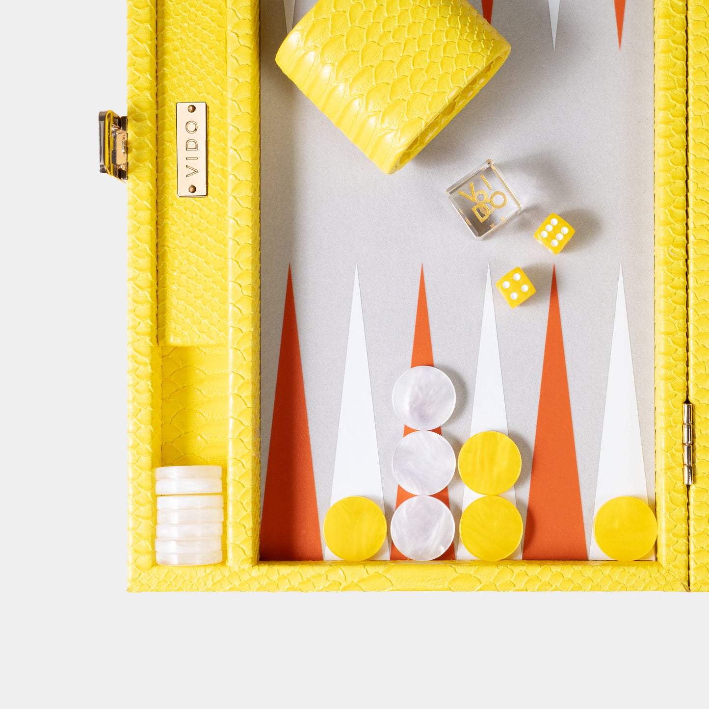 Yellow backgammon box with checkers, dice, and game pieces on a white background by VIDO